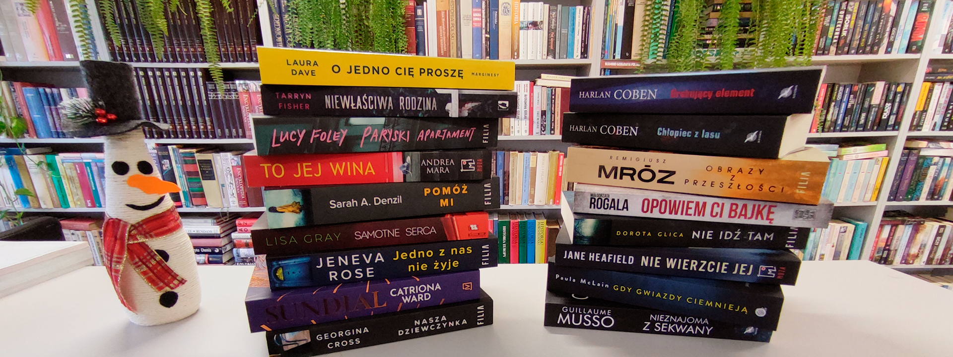 Dwa stosy książek w tle półki z książkami